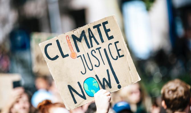 Manifestante con cartel reclamando justicia climática