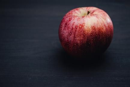 Manzana roja sobre superficie oscura