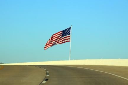 Carretera y bandera de los Estados Unidos. Photo by Bravo Prince on Unsplash