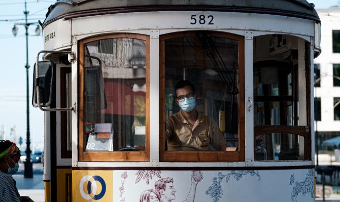 Conductor de tranvía y pasajera con mascarillas en Lisboa