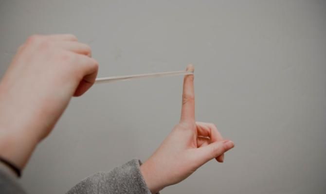 Manos de niño estirando una goma elástica. Photo by Kenny Eliason on Unsplash