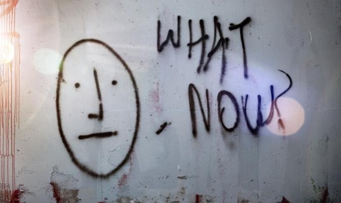 Grafiti en un muro con el dibujo de una cara y la inscripción "What now?". Photo by Tim Mossholder on Unsplash