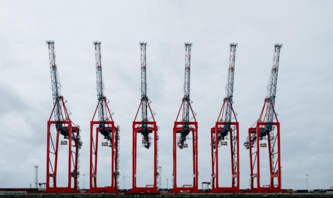 Seis gruas de mercancias en el puerto de Hamburgo. Photo by Claudio Schwarz on Unsplash