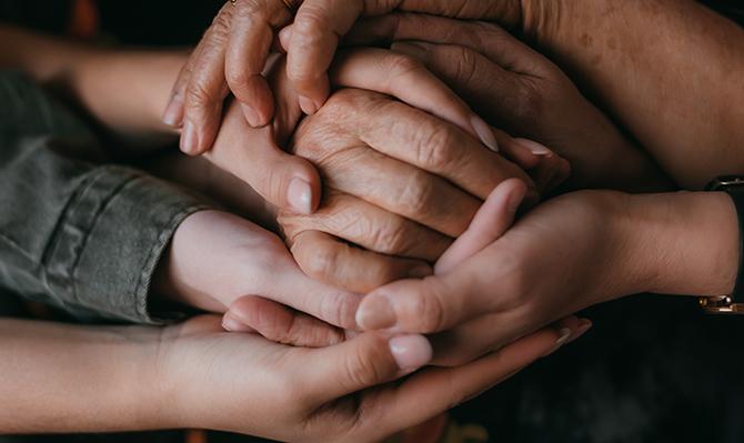 Manos enlazadas de personas de distintas edades