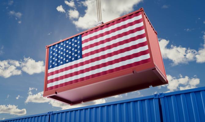 Contendor de mercancías con la bandera de Estados Unidos izado por una grua