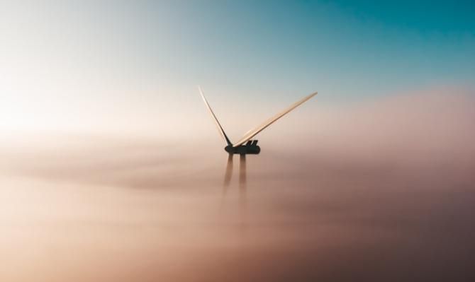 Molino de viento entre las nubes. Photo by Sander Weeteling on Unsplash