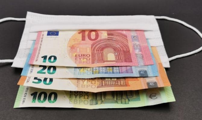 Billetes de 10, 20, 50 y 100 euros sobre una mascarilla. Photo by Nedret Binici on Unsplash