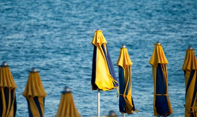 Sombrillas cerradas en una playa para ilustrar un artículo de análisis económico de CaixaBank Research sobre turismo en España. Photo by Iridial on Unsplash
