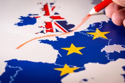 Mapa de Europa con las banderas de la UE y de Reino Unido y una mano dibujando una línea roja entre las islas británicas y el continente