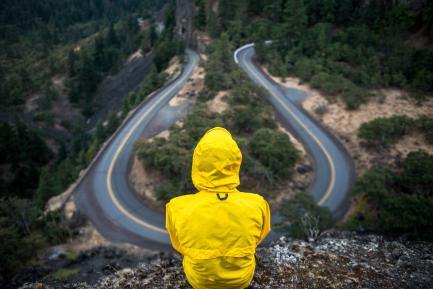 Figura con chubasquero amarillo enfrente de una carretera