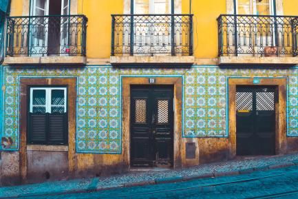 Fachada de una casa lisboeta con azulejos de color verde, blanco y amarillo