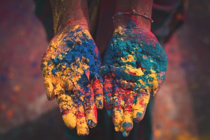 Manos mostrando pigmentos de colores en la festividad hindú de Holi, India