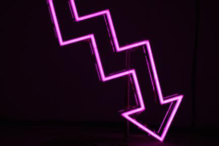 Luz de neón violeta en forma de flecha descendente