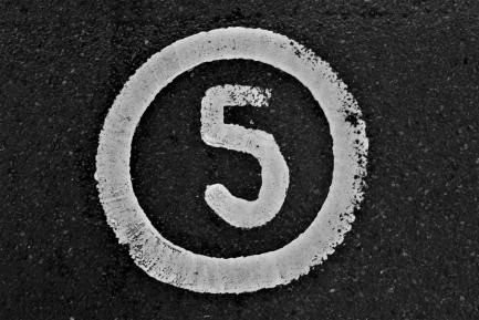 Número 5 escrito en blanco sobre el asfalto