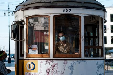 Conductor de tranvía y pasajera con mascarillas en Lisboa