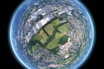 A 360 panorama stitched and warped to create the tiny planet effect. Image sequence taken by drone above a community field in Wales.