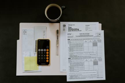 Calculadora, documentos para la declaración de impuestos, taza