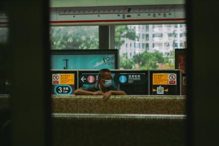 Hombre con mascarilla en una estación china. Photo by Joshua Fernandez on Unsplash