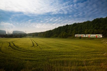 Campo verde, tren y fabrica. Photo by Robert Wiedemann on Unsplash