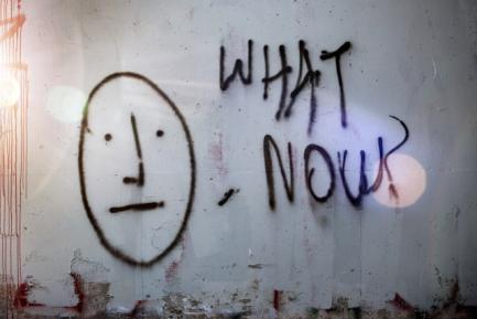 Grafiti en un muro con el dibujo de una cara y la inscripción "What now?". Photo by Tim Mossholder on Unsplash