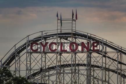 Monataña rusa con banderas de Estados Unidos y un cartel que reza "Cyclone". Photo by Michael Chiara on Unsplash