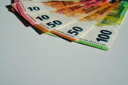 Billetes de euro dispuestos en forma de abanico sobre un fondo blanco. Photo by John Vid on Unsplash