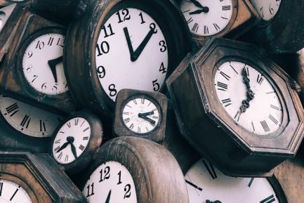 Pila de relojes antiguos de pared de madera. Photo by Jon Tyson on Unsplash