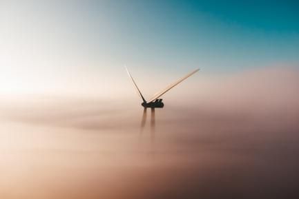 Molino de viento entre las nubes. Photo by Sander Weeteling on Unsplash