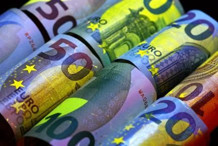 Rollos de billetes de euro bajo luz de infrarrojos. Photo by Immo Wegmann on Unsplash