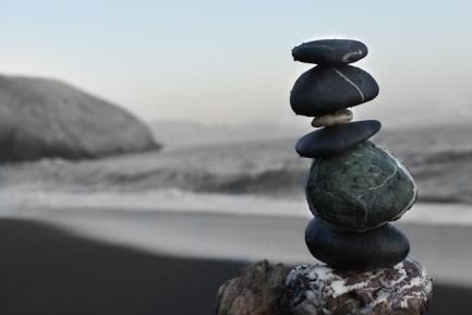 Piedras apiladas en una playa para ilustrar un artículo de opinión sobre la economía internacional de CaixaBank Research. Photo by Colton Sturgeon on Unsplash