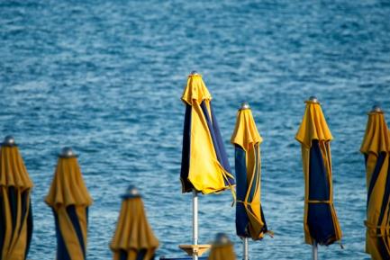 Sombrillas cerradas en una playa para ilustrar un artículo de análisis económico de CaixaBank Research sobre turismo en España. Photo by Iridial on Unsplash
