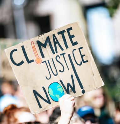 Manifestante con cartel reclamando justicia climática