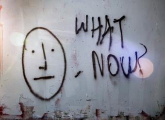 Grafiti en un muro con el dibujo de una cara y la inscripción "What now?". Photo by Tim Mossholder on Unsplash