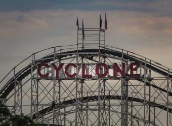 Monataña rusa con banderas de Estados Unidos y un cartel que reza "Cyclone". Photo by Michael Chiara on Unsplash