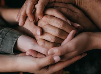 Manos enlazadas de personas de distintas edades