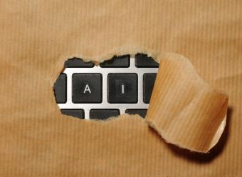 Teclado de ordenador donde se ven las letras "A" e "I" a través del agujero de un papel kraft que cubre el resto de letras. Photo by Immo Wegmann on Unsplash