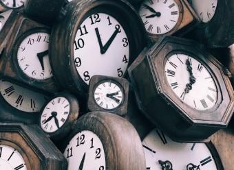 Pila de relojes antiguos de pared de madera. Photo by Jon Tyson on Unsplash