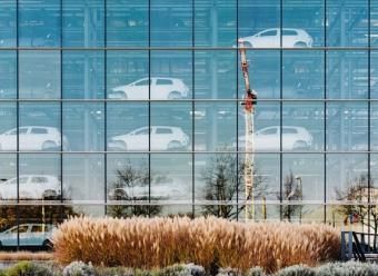 Edificio acristalado con coches nuevo almacenados en su interior. Photo by Maksym Kaharlytskyi on Unsplash