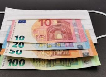 Billetes de 10, 20, 50 y 100 euros sobre una mascarilla. Photo by Nedret Binici on Unsplash