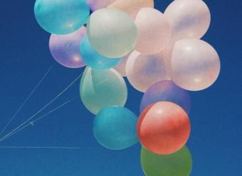 Globos de colores en cielo azul con nube. Photo by Diya Pokharel on Unsplash