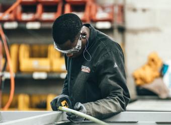 Obrero trabajando en un taller o fábrica para ilustrar el análisis económico de CaixaBank Research sobre el mercado laboral en España. Photo by Spencer Davis on Unsplash