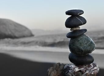 Piedras apiladas en una playa para ilustrar un artículo de opinión sobre la economía internacional de CaixaBank Research. Photo by Colton Sturgeon on Unsplash