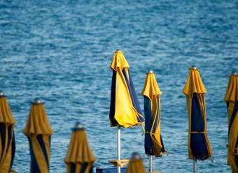 Sombrillas cerradas en una playa para ilustrar un artículo de análisis económico de CaixaBank Research sobre turismo en España. Photo by Iridial on Unsplash